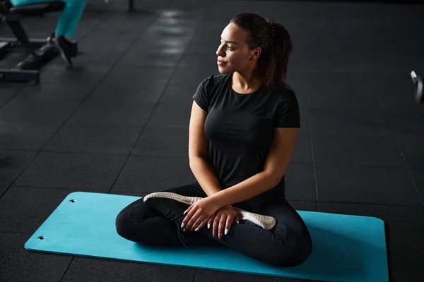Mujer joven haciendo ejercicios de yoga en el gimnasio — Foto de Stock