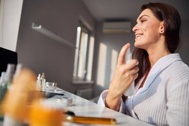 Yüzüne sprey sıkan güzel kumrala yaklaş.