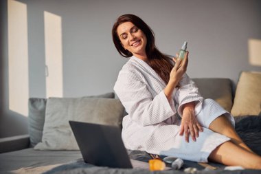 Bilgisayarının ekranına bakan memnun bir kadın.