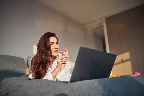 Potěšená brunetka žena dívá přímo do kamery — Stock fotografie