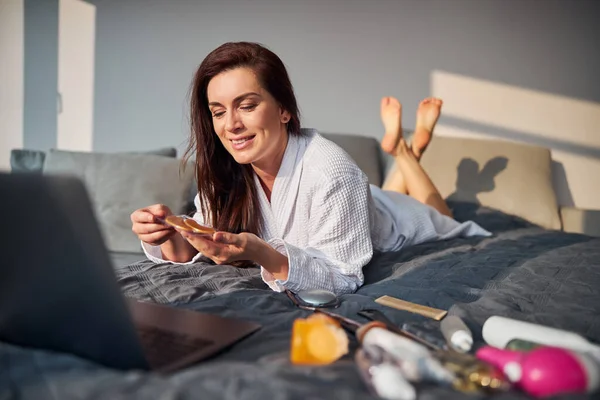 Mujer alegre haciendo procedimientos de belleza en casa — Foto de Stock