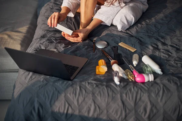 Zaměstnaná žena dělá pedikúru na posteli — Stock fotografie