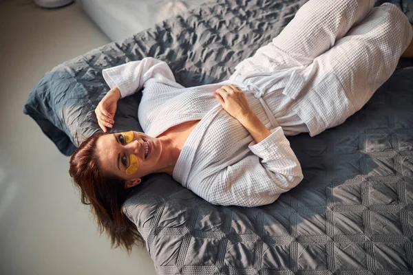 Tampilan atas foto wanita bahagia berbaring di tempat tidur — Stok Foto