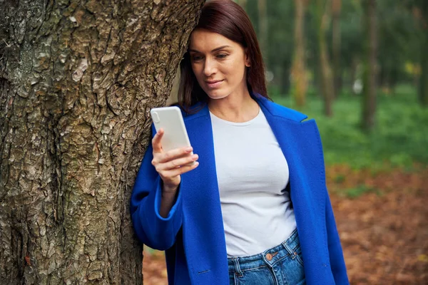 Persona femenina relajada apoyada en el árbol —  Fotos de Stock