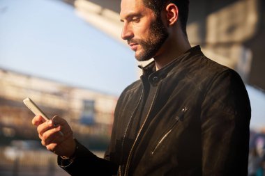 Sokaklarda modern aletler kullanan yakışıklı bir adamın portresi.