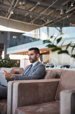 Modern aletlerle düşünceli bir iş adamı tek başına oturuyor.