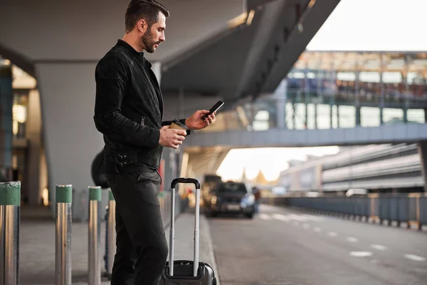Ernsthafter Reisender mit Smartphone und Kaffee im Freien — Stockfoto