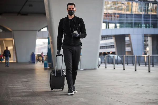 Turista masculino caminando con equipaje durante la pandemia —  Fotos de Stock