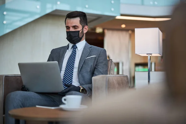 Tranquilo hombre de negocios utilizando gadget moderno en el aeropuerto —  Fotos de Stock