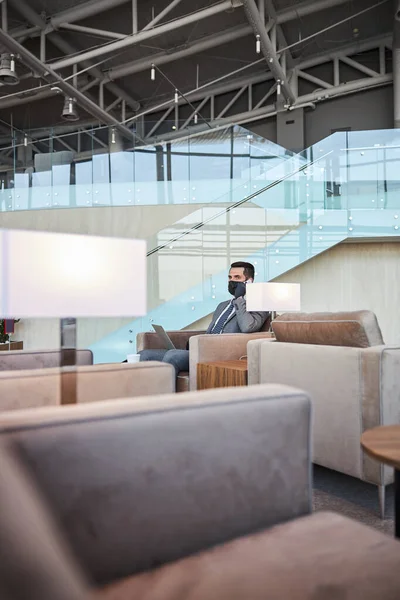 Calm man answering the phone call in airport lounge zone — Stock Photo, Image