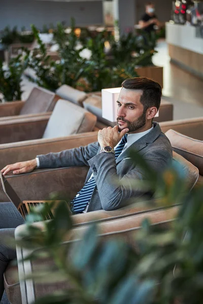 Worried businessman frowning and touching his chin — Stock Photo, Image