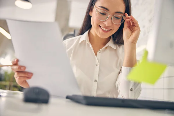 Porträt einer charmanten Frau beim Betrachten ihrer Notizen — Stockfoto