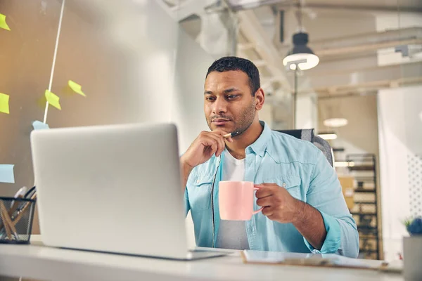 Gedachte internationale man staren naar scherm van laptop — Stockfoto