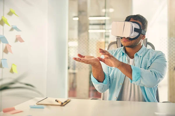 Freundliche Brünette sitzt in Maske für virtuelle Realität — Stockfoto