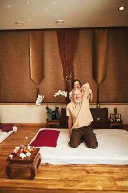 Neşeli erkek, doğu stüdyosunda rehabilitasyon egzersizlerinin keyfini çıkarıyor.