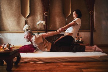 Doğu stüdyosundaki iyileşme egzersizleri sırasında olgun bir adam.