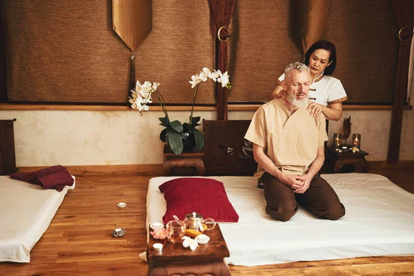 Homem feliz relaxante durante tradicional asiático massagem — Fotografia de Stock