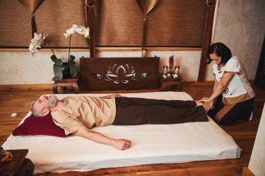 Sakin, olgun bir adam doğu stüdyosunda ayak tedavi ediyor.