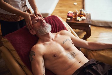 Sakallı sakin adam Tayland kaplıcasında dinleniyor.