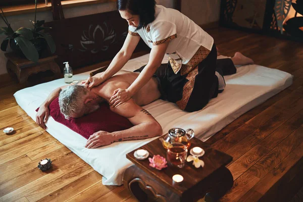 Grizzled mężczyzna podczas tajskiego masażu w spa — Zdjęcie stockowe
