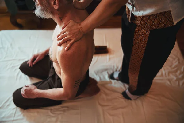 Mulher fazendo massagem para ombros masculinos no centro de spa — Fotografia de Stock