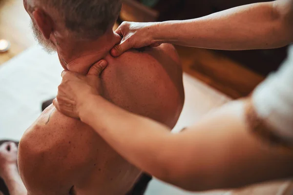 Vrouwelijke manuele therapeut behandelen van mannelijke nek binnen — Stockfoto