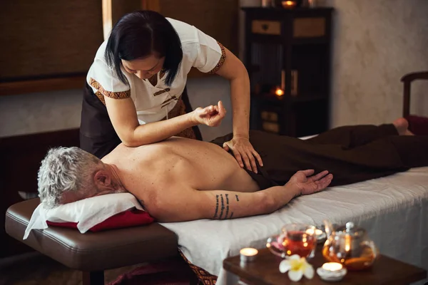 Aziatische vrouw doet traditionele thai massage voor man — Stockfoto