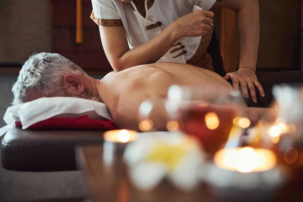 Thai manual therapist healing male back in studio — Stock Photo, Image
