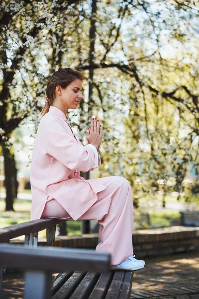 Женщина сидит боком, медитируя с молитвенным жестом — стоковое фото