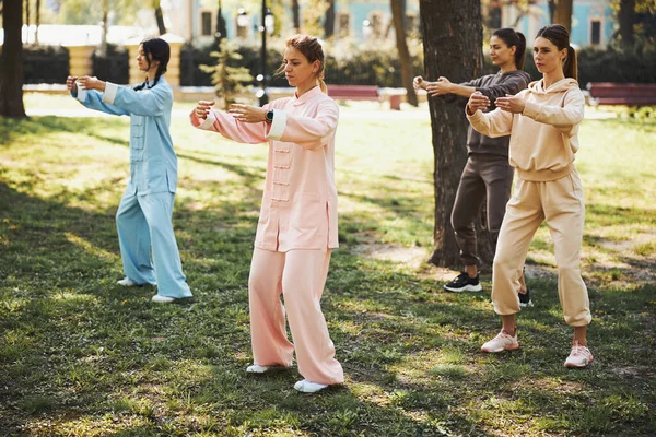 Praktykujący Qigong owijają ramiona wokół pustej przestrzeni przed nimi — Zdjęcie stockowe