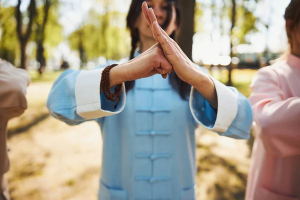 Mujer haciendo puño chocar contra la palma durante tai chi —  Fotos de Stock