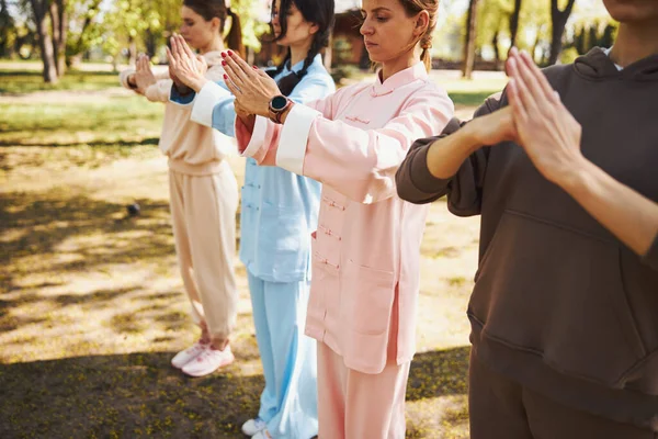 Gente terminando la actividad tai chi con saludo de puño en espera —  Fotos de Stock