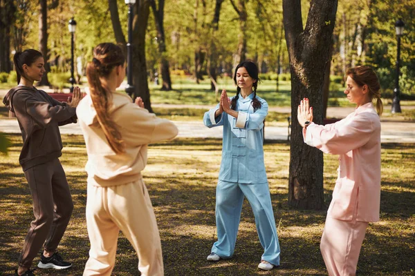 Женщины стоят в кругу и медитируют в парке — стоковое фото