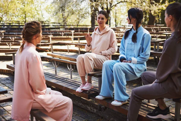 Kvinnor chattar med varandra utanför arenan bänk — Stockfoto