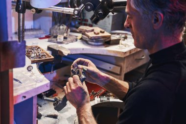 Mücevher imalatçısı ametist öğütme için mücevher kesme aracı ile çalışıyor.