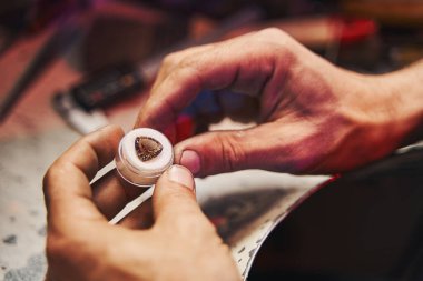 Goldsmith küçük bir kutuda yüzleri olan elmas üzerinde çalışıyor.