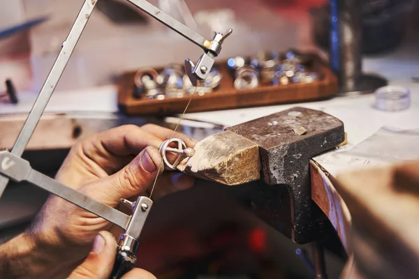 Craftsman using fretsaw for cutting steel jewelry product — Stock Photo, Image