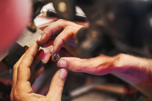 Joalheiro está segurando diamante cortado entre os dedos — Fotografia de Stock