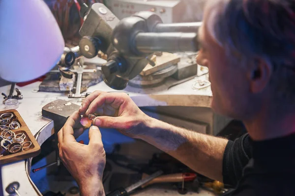 Odaklanmış mücevher imalatçısı işten önce mücevheri kontrol ediyor — Stok fotoğraf