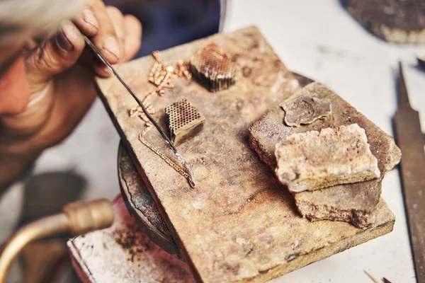 Jewelry making specialist using solder alloy on golden chain — Stock Photo, Image