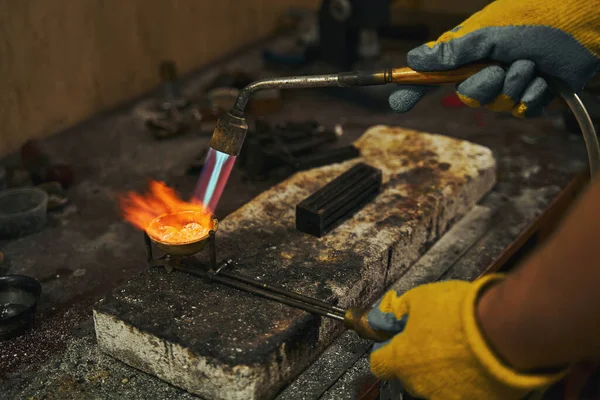 Голдсміт тримає розп'яття дорогоцінним металом під час виплавки — стокове фото