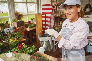 Sulama kabıyla gülümseyen son sınıf öğrencisi kadın.