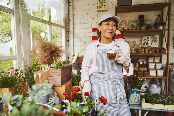 Krásná zralá žena prodej rostlin v obci shop — Stock fotografie