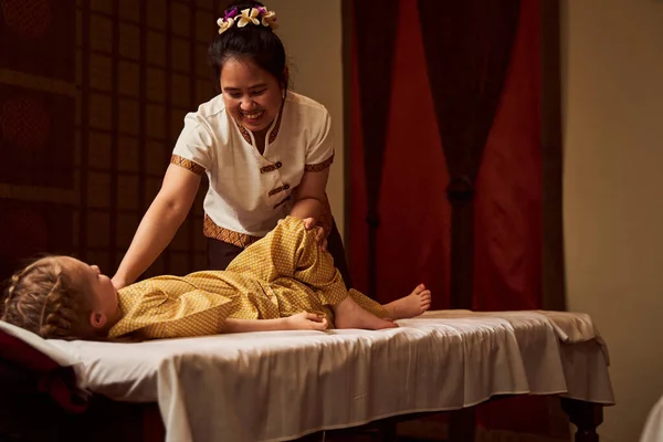 Terapeuta de uniforme fazendo massagem para criança — Fotografia de Stock