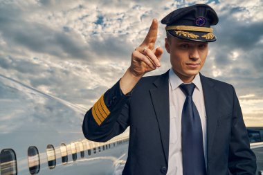 Genç havayolu pilotu kalkışa hazır olduğunu gösteriyor.