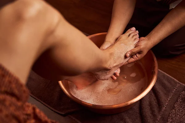 Spa salonundaki özel konteynırda ayak yıkayan deneyimli bir ayak bakım uzmanı. — Stok fotoğraf