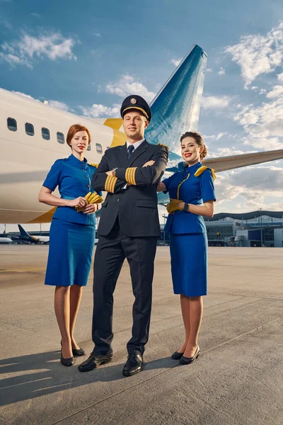 Roztomilý kapitán aerolinek a letušky stojící u airdrome — Stock fotografie