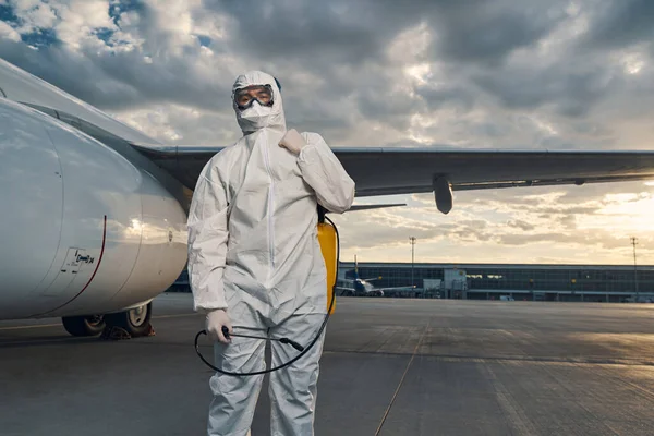 Hombre con traje de materiales peligrosos parado en el aeródromo — Foto de Stock