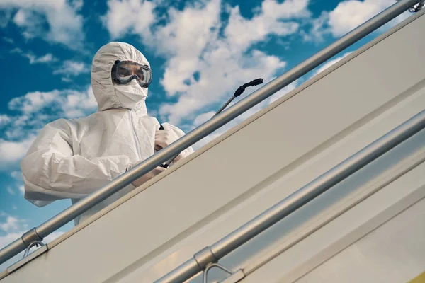 Trabajador enfocado desinfectando la barandilla en las escaleras — Foto de Stock