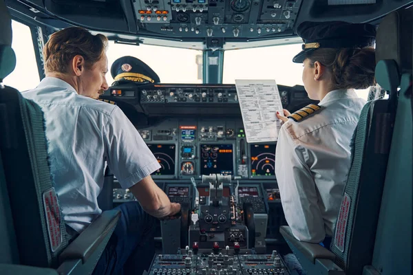 Пілот і перша жінка-офіцер сидять у польотній палубі — стокове фото
